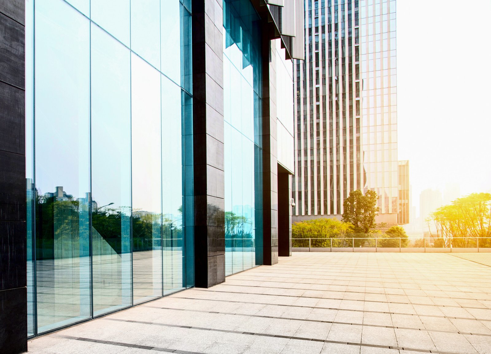 Modern glass office building with blue-tinted panels and reflections on the façade.